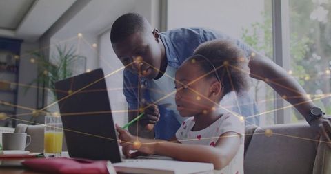 Black father guiding daughter learning on laptop at home with digital network overlay
