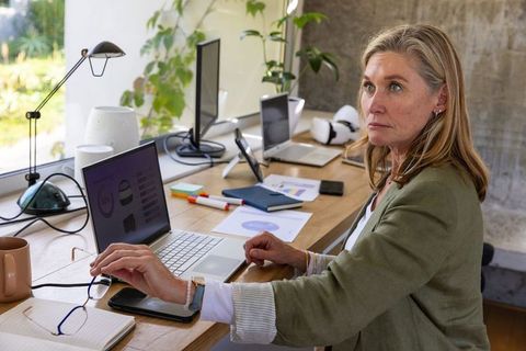 Confident Senior Woman Analyzing Data at Home Office with Technology
