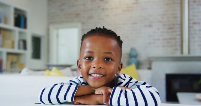 Smiling African American Child Relaxing at Home in Striped Shirt - Download Free Stock Images Pikwizard.com