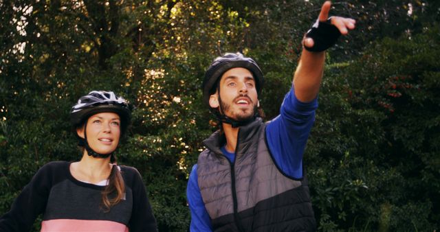 Outdoor Adventure Couple Pointing While Mountain Biking in Forest - Download Free Stock Images Pikwizard.com