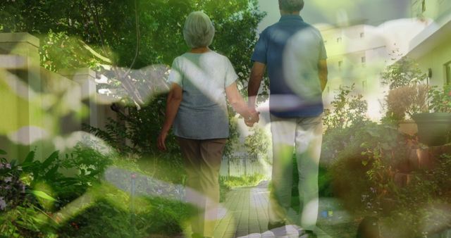 Composite image of close up of leaves against senior couple holding hands walking in the garden. love and relationship concept