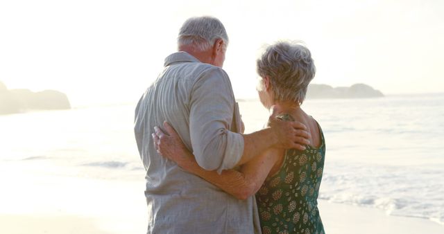 Elderly couple embracing while standing on beach at sunset - Download Free Stock Images Pikwizard.com