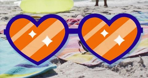 Vibrant Heart-Shaped Sunglasses on Beach Towels at Coastline