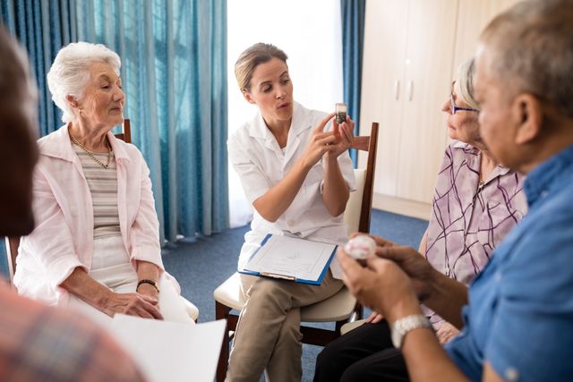 Female doctor explaining medicine to a group of seniors at a retirement home. Ideal for use in healthcare, elderly care, senior living, and medical consultation contexts. Can be used in brochures, websites, and articles related to senior healthcare and patient education.