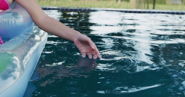 Relaxing by Swimming Pool Touching Water Ripples on Float - Download Free Stock Images Pikwizard.com