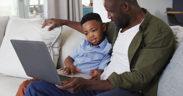 African american father and son using a laptop together - Download Free Stock Photos Pikwizard.com