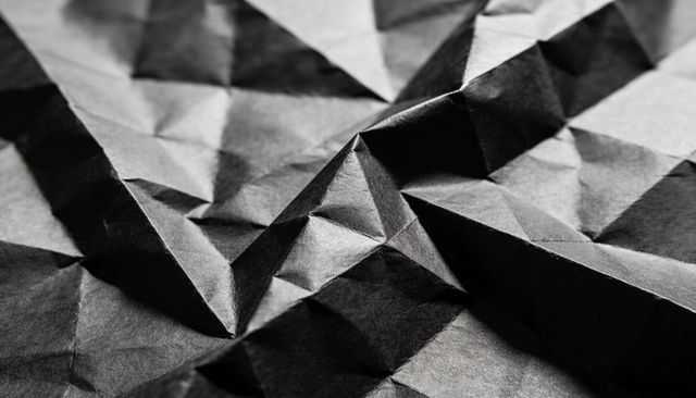 Crumpled Black Paper Texture with Pyramid Peak and Sharp Geometric Folds, Monochrome Macro