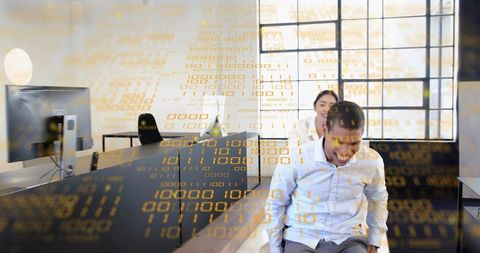 Laughing colleagues sharing moment in sunlit modern workspace with digital data overlay