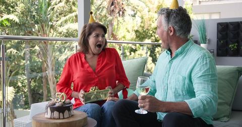Senior couple celebrating 50th birthday on outdoor balcony