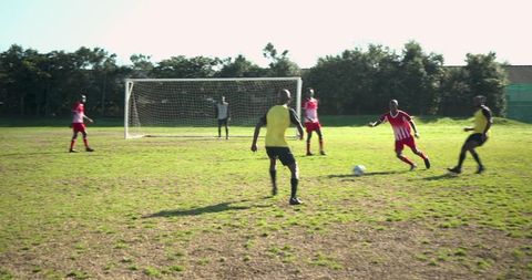 African male soccer players competing on sunny field