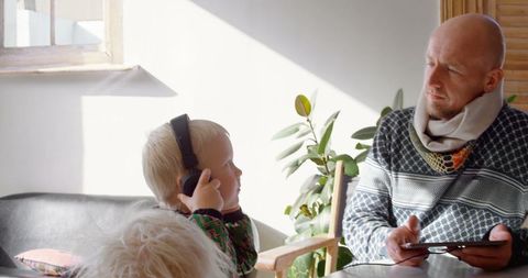 Father and Children Listening to Music on Tablet at Home