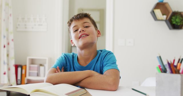 Portrait of caucasian boy with arms crossed smiling looking at the camera at home. distance learning and online education concept