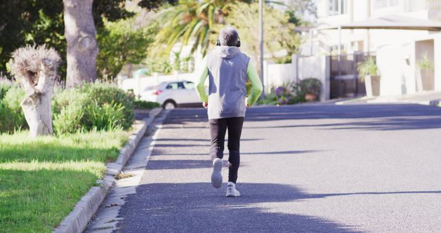 Person Jogging on Suburban Street in Morning Light - Download Free Stock Images Pikwizard.com