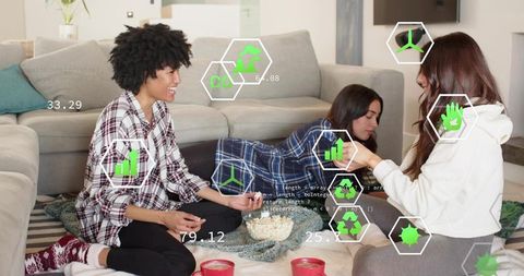 Friends lounging on living room rug sharing popcorn and mugs in cozy loungewear