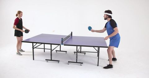 Competitive ping pong match between female and male players