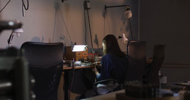 Solitary Craftsperson Focused on Intricate Work in Dimly Lit Workshop - Download Free Stock Images Pikwizard.com