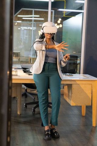 African american businesswoman using vr headset in modern office for virtual collaboration