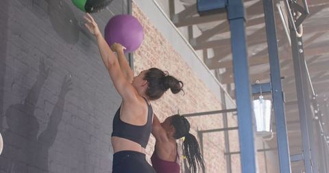 Women Engaging in Intense Medicine Ball Workout Session for Fitness