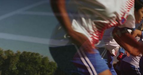 Female athletes sprinting in white jerseys red stripes and blue shorts in soccer drill