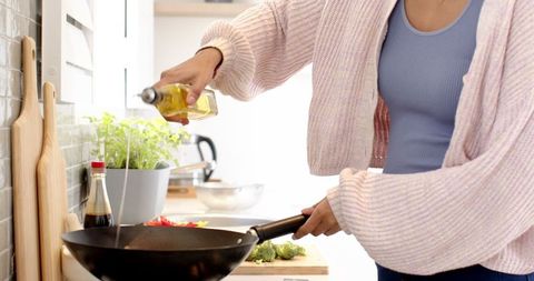 Indian woman cooking vegetables in modern kitchen