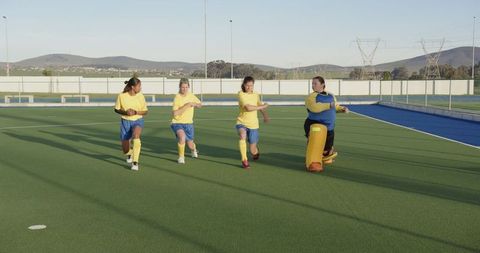 Diverse Female Athletes Stretching on Sports Field