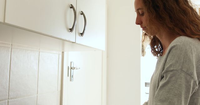 Woman with Curly Hair Prepares Meal in Modern Kitchen - Download Free Stock Images Pikwizard.com