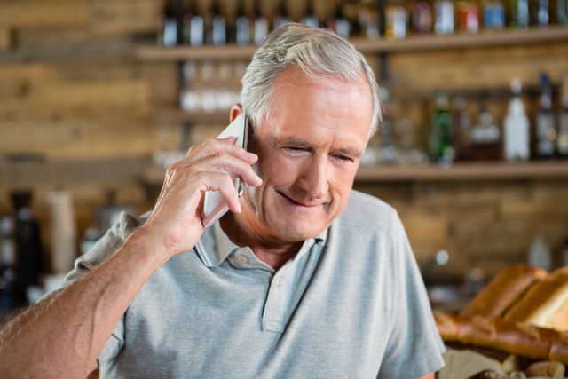 Senior Man Talking on Mobile Phone in Café - Download Free Stock Photos Pikwizard.com
