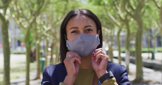 Woman Adjusting Face Mask Outdoors on a Sunny Day - Download Free Stock Images Pikwizard.com