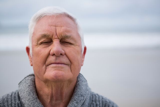 Senior man with eyes closed standing at the beach