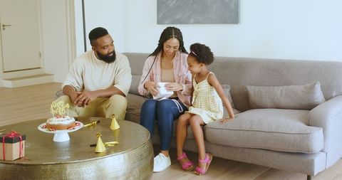 Family Celebrating Mother's Birthday at Home with Present