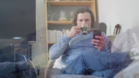 Man Relaxing with Coffee and Smartphone Overlaying Winter Landscape