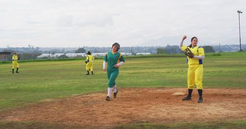 Female Athletes Playing Competitive Softball Game Outdoors