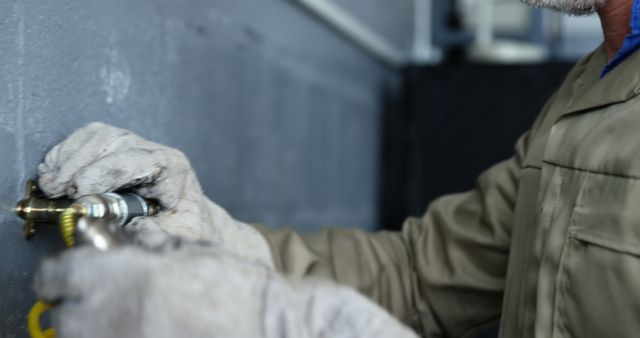 Handyman Repairing Wall Pipe in Gray Uniform and Gloves - Download Free Stock Images Pikwizard.com