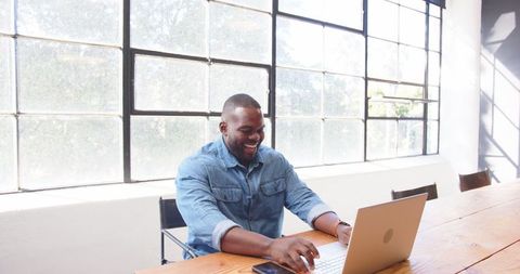 Joyful Professional Celebrating Success at Office Desk with Laptop