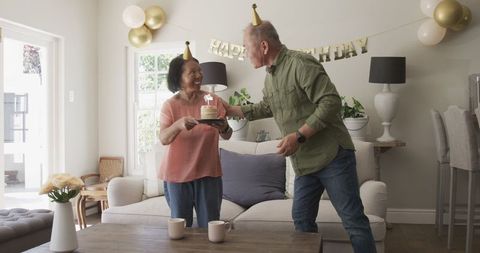 Senior Couple Celebrating Birthday with Cake and Decorations at Home