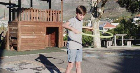Boy Exercising with Hula Hoop in School Playground