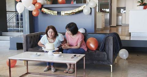 Senior Friends Celebrating Birthday at Home with Cake and Decorations
