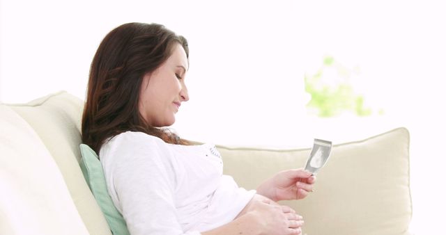 Happy Pregnant Woman Relaxing on Couch with Ultrasound Photo - Download Free Stock Images Pikwizard.com