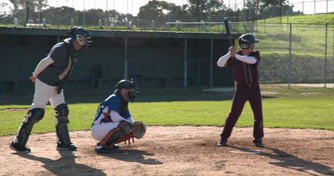 Baseball players in action: batter, catcher and umpire in game