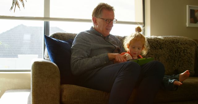 Grandfather and Granddaughter Bonding on Living Room Sofa with Digital Tablet - Download Free Stock Images Pikwizard.com