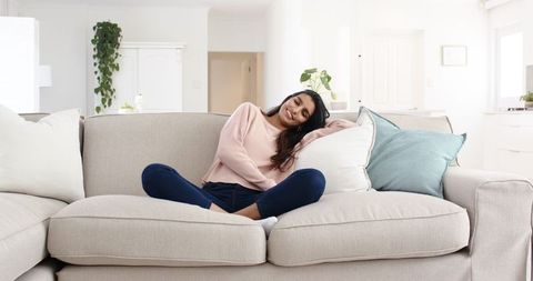 Relaxed Woman Lounging on Comfortable Sectional Sofa at Home