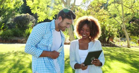 Happy Multiracial Couple Using Tablet in Sunny Park - Download Free Stock Images Pikwizard.com