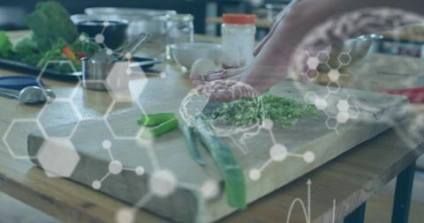 Hands pressing fresh herbs on wooden cutting board with scallions and molecular overlay