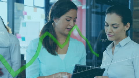 Businesswomen Analyzing Data on Digital Tablet in Office Environment