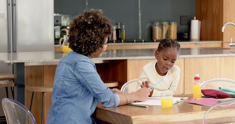 Mother and Daughter Bonding Over Homework in Modern Kitchen