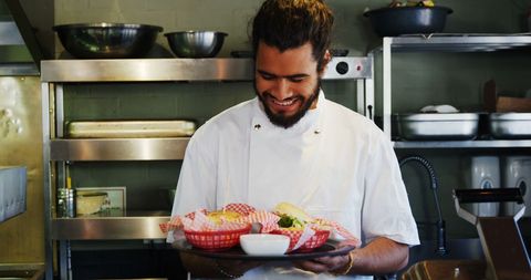 Smiling Young Chef Presenting Dishes in Professional Kitchen - Download Free Stock Images Pikwizard.com