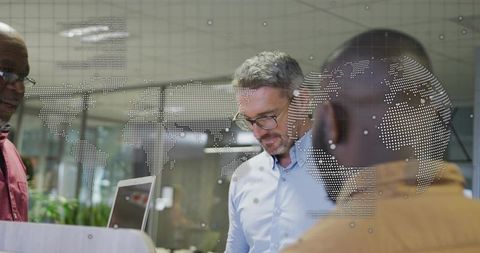 Global collaboration team reviewing analytics on laptop with dotted world map overlay