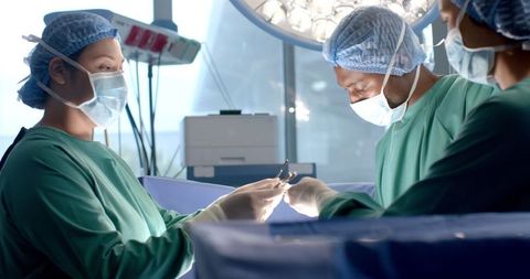 Diverse medical team performing surgery in modern hospital