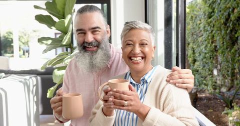 Senior Couple Enjoying Morning Coffee at Home with Warm Smiles