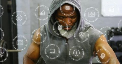 Mature athlete lifting dumbbells in hooded vest, focused strength with tech overlay
